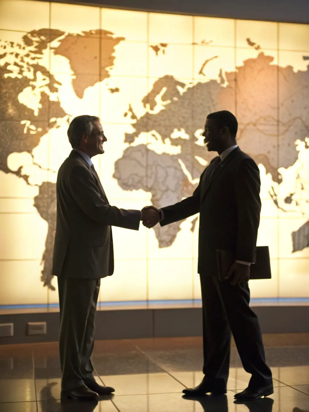 A digital illustration of two hands shaking over a world map, symbolizing successful brokerage deals facilitated by ShipSyn's support services.