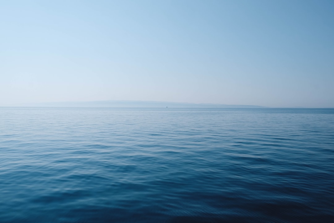 body-of-water-under-blue-and-white-sky-at-daytime-iz01rjx0xqa